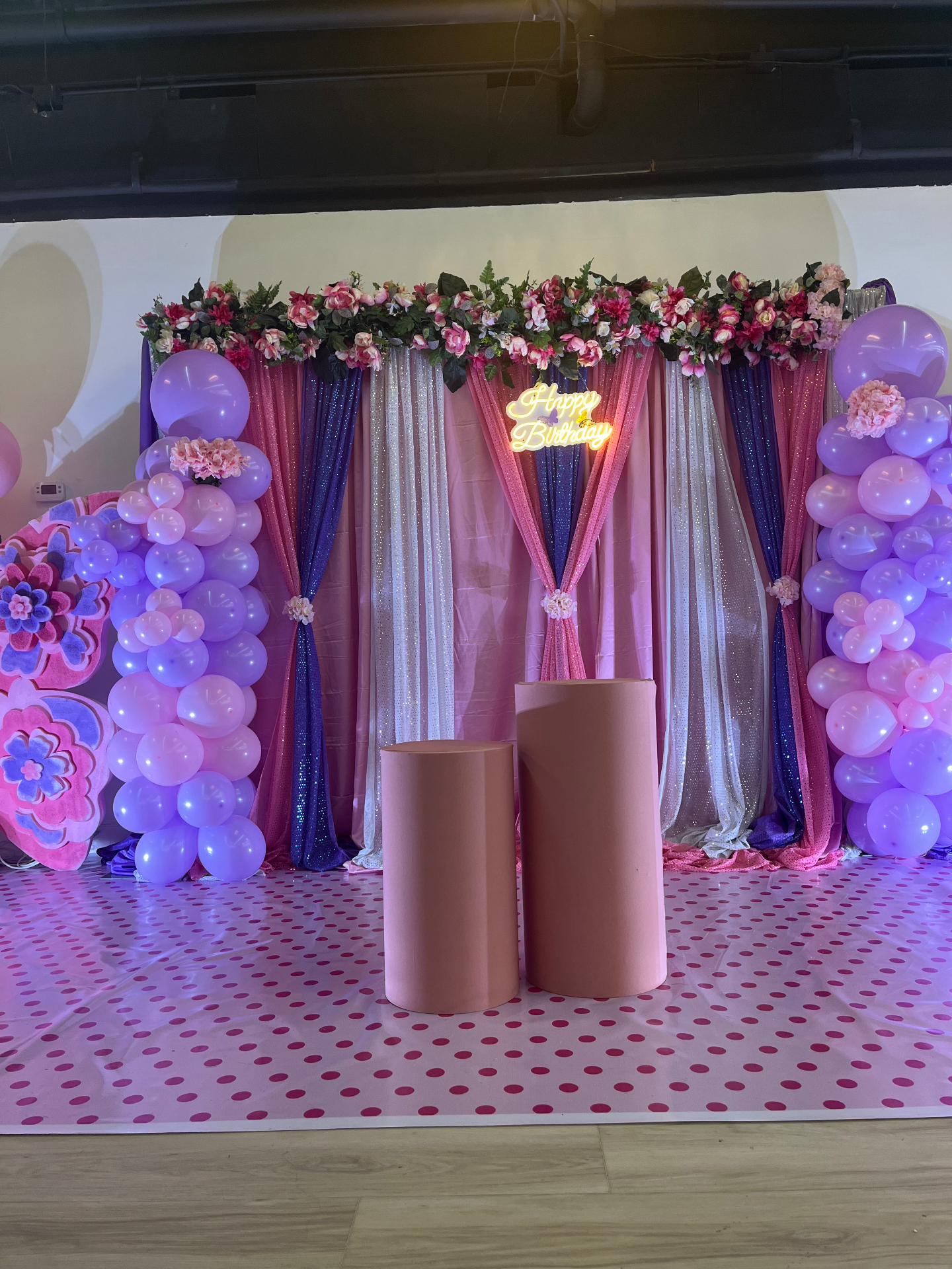 Pink and purple floral birthday arch with patterned floor