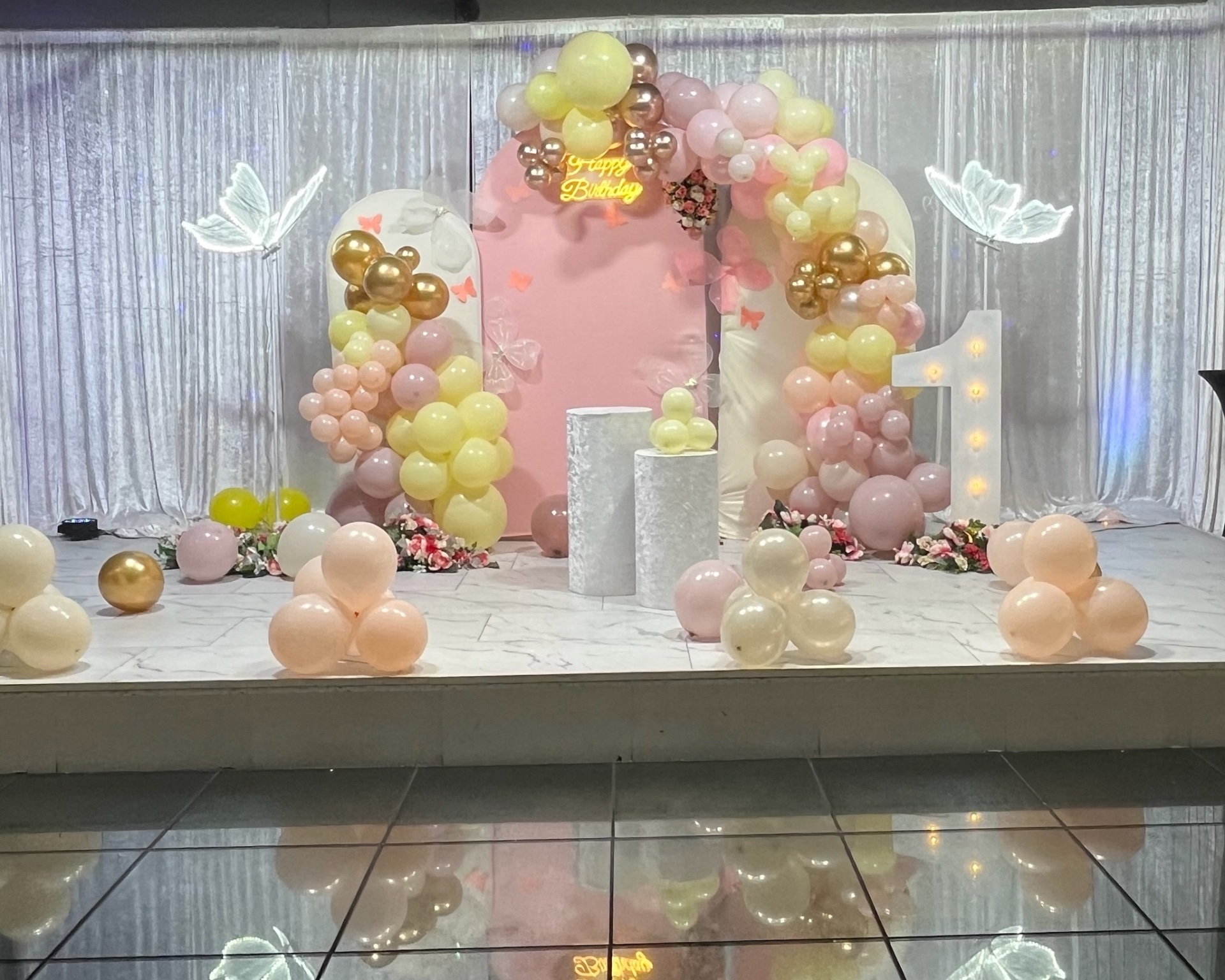 Pastel first birthday balloon arch with illuminated number one