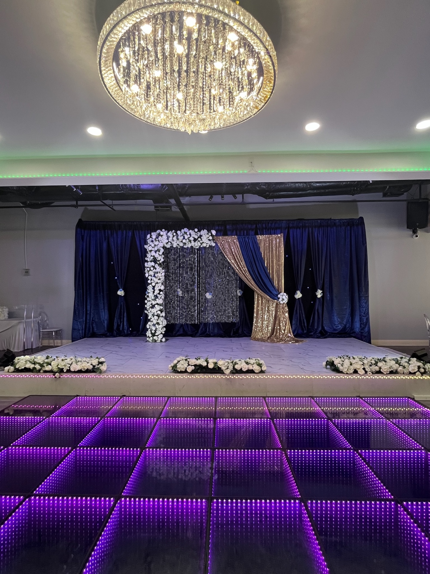 Navy and gold reception with crystal backdrop and illuminated dance floor