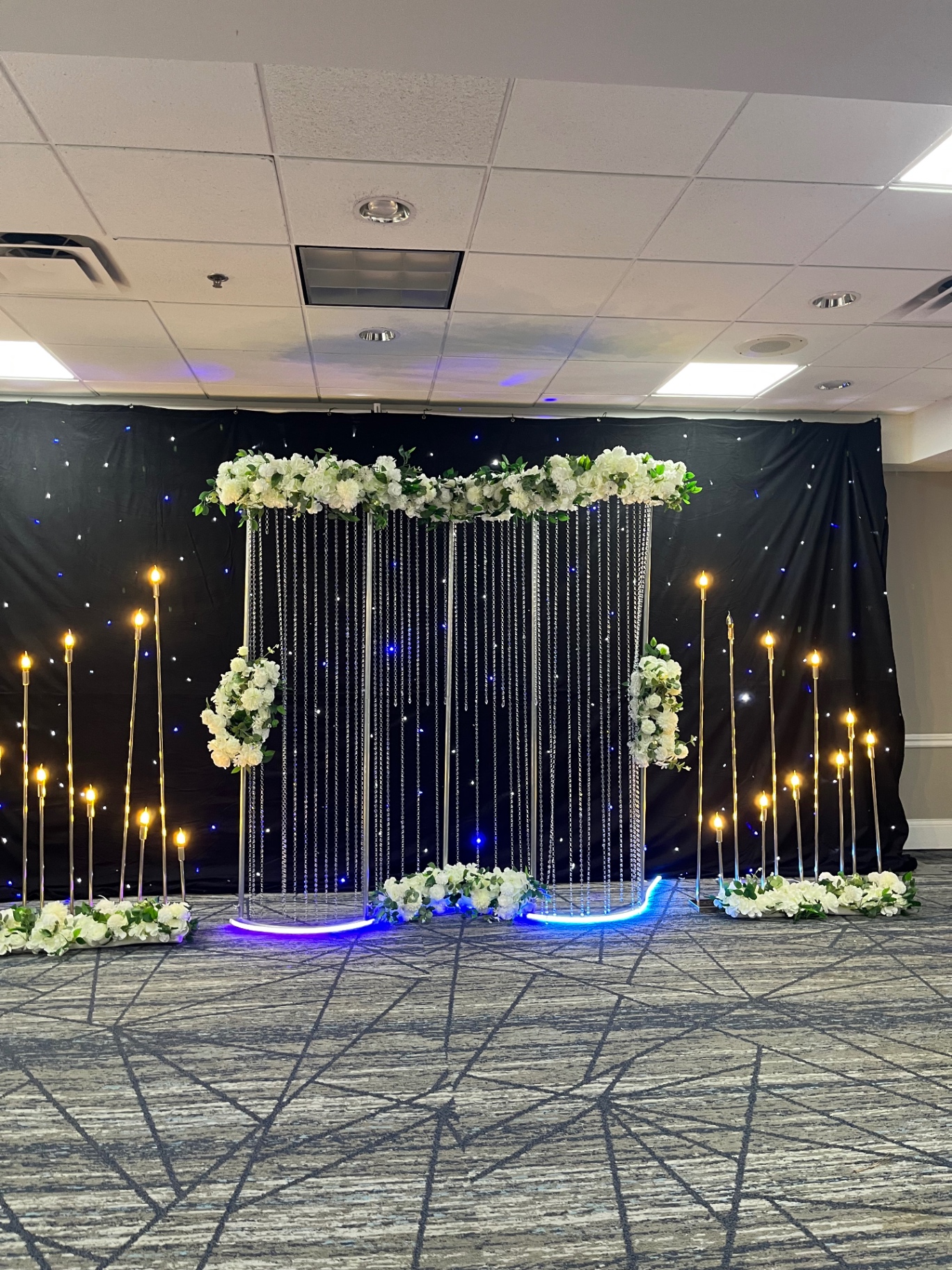 White floral arch with crystal strands and starlight backdrop