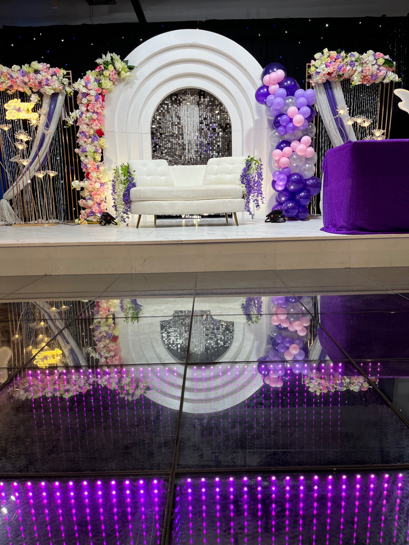 White floral birthday arch with elegant seating