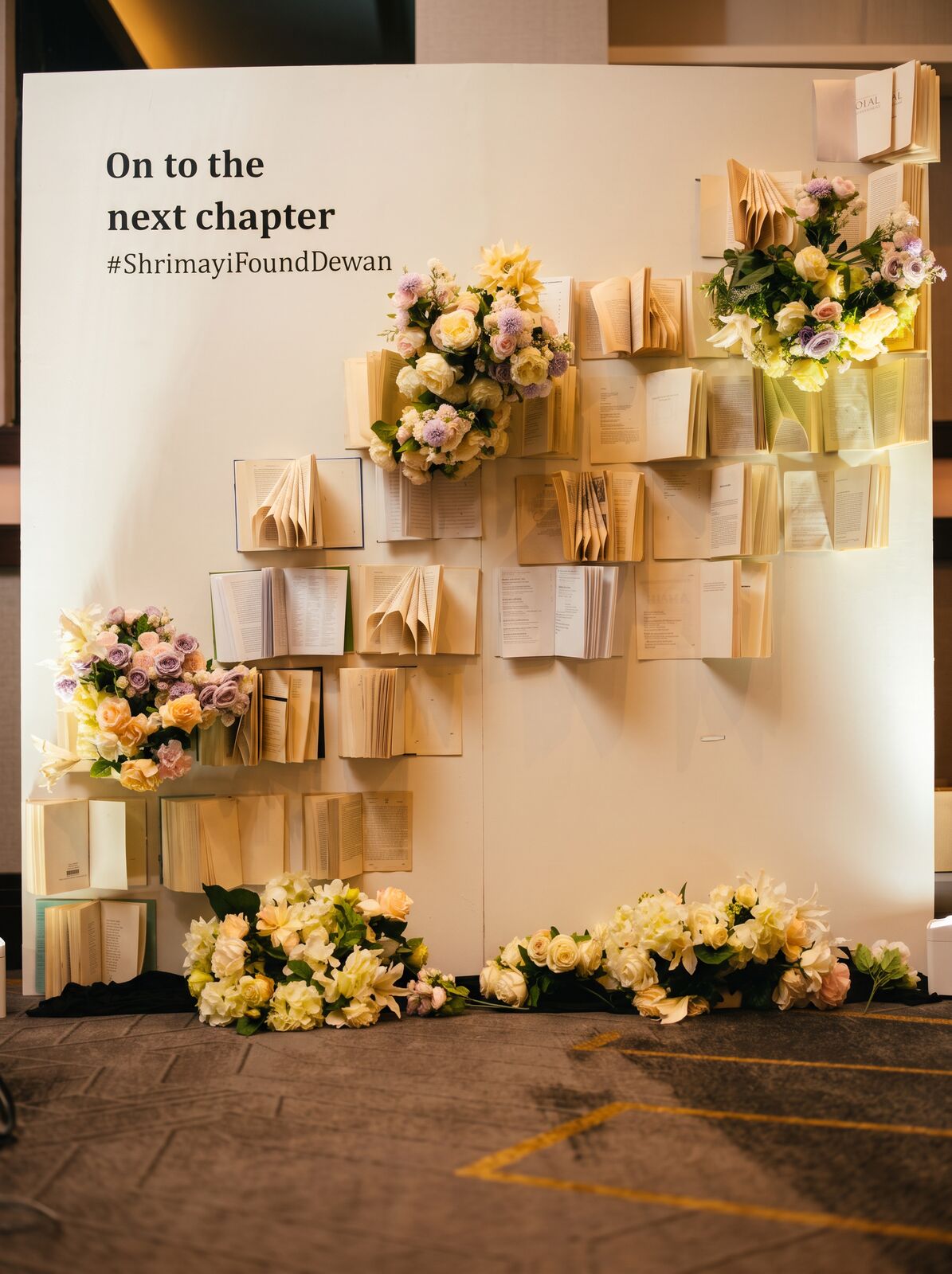 Floral book-wall engagement backdrop