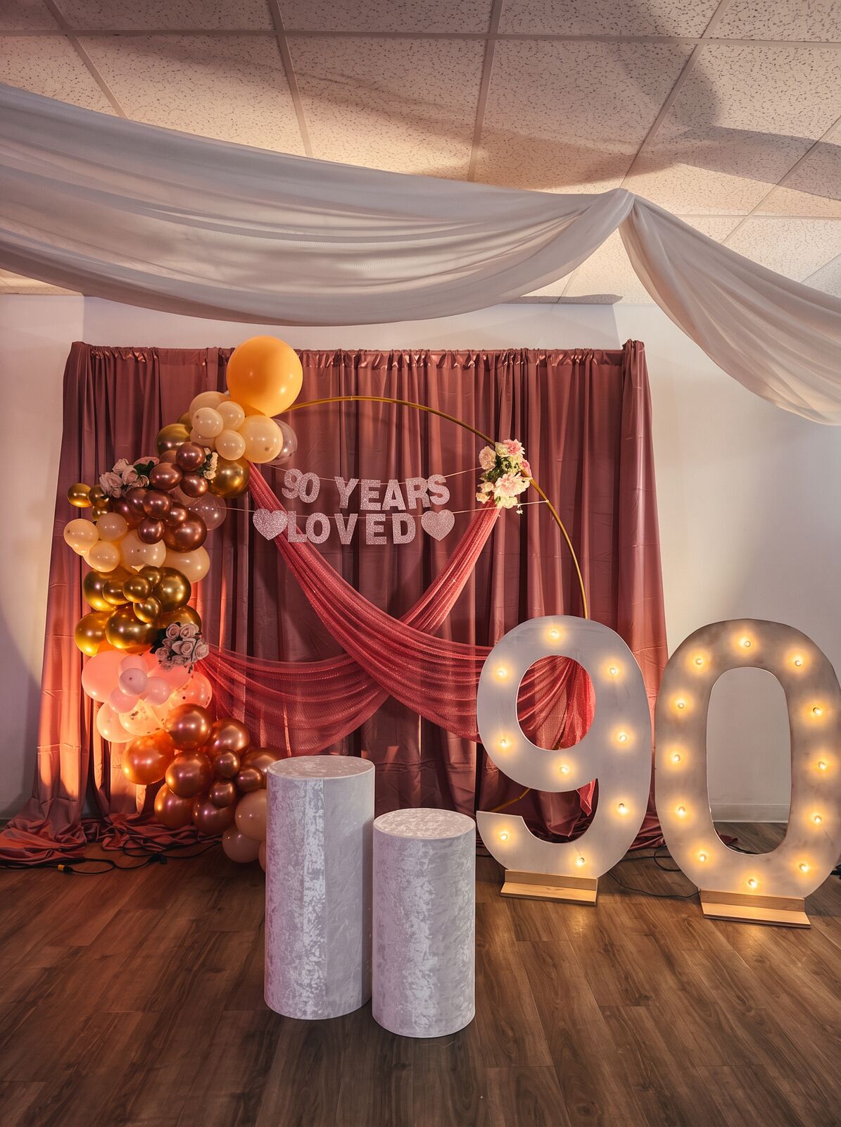 Ninetieth birthday setup with rose-gold balloons