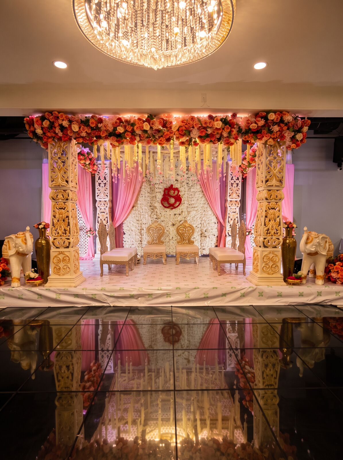 Ornate pink and ivory mandap with carved pillars
